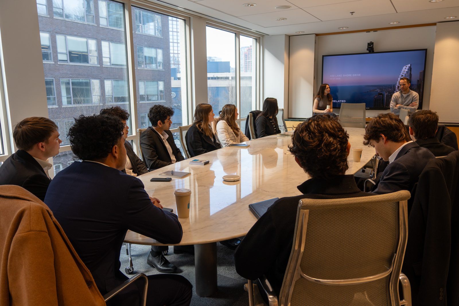 Members seated around a conference table listening to a presentation.