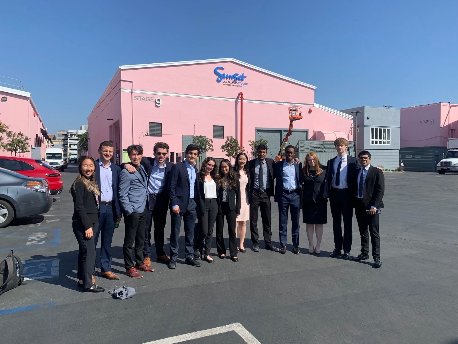 The group outside a pink soundstage on a Los Angeles studio lot.