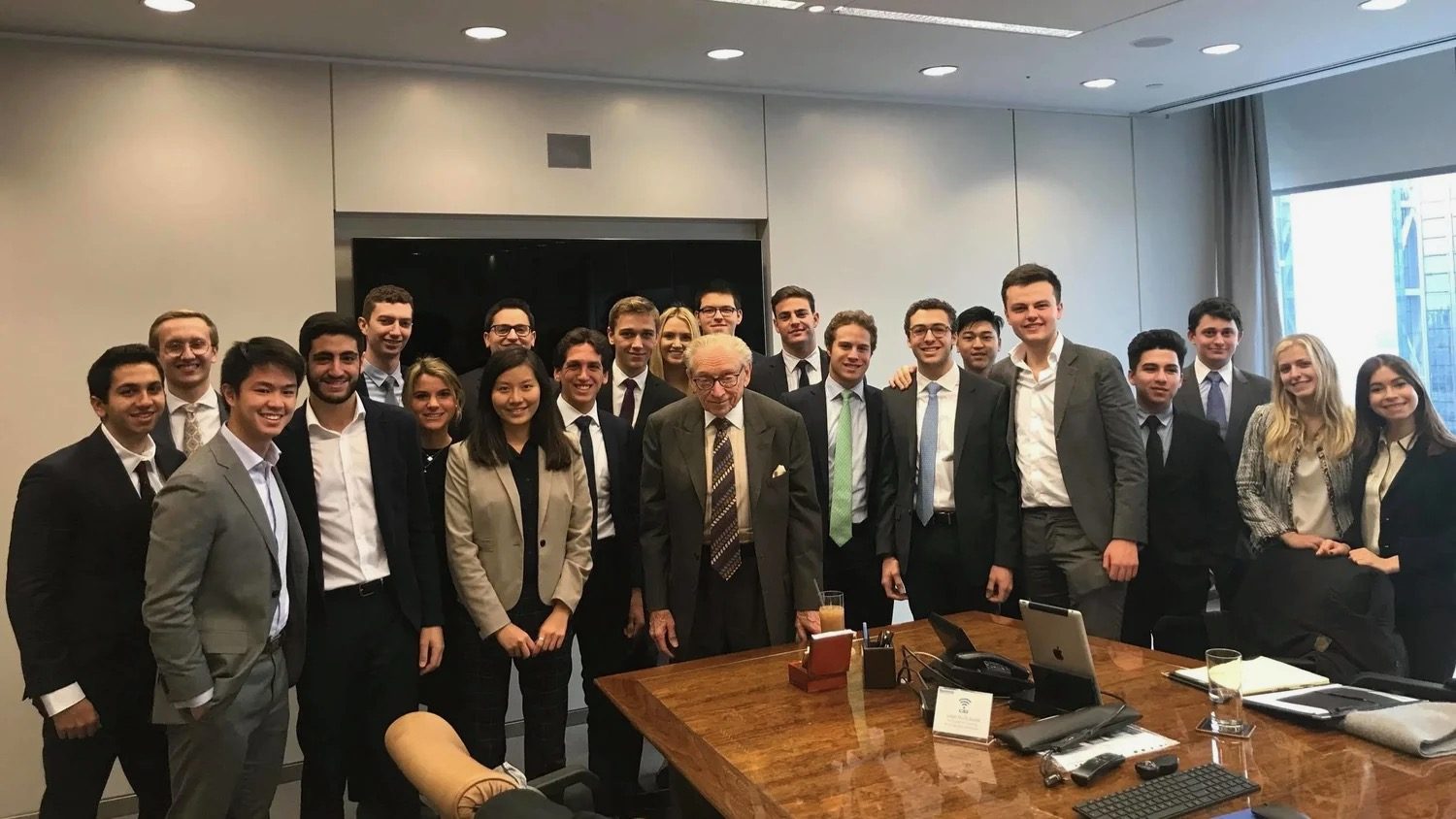 Members gathered around an executive's desk at a New York firm.
